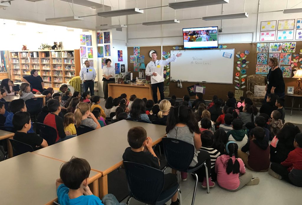 Patrick lecturing a classroom of youth